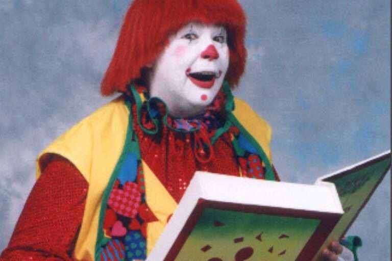 Clown reading from a large book